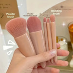 Set of makeup brushes held in a hand with labels on a blurred background