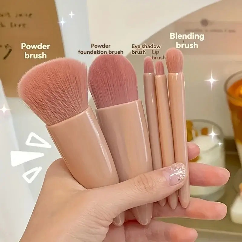 Set of makeup brushes held in a hand with labels on a blurred background