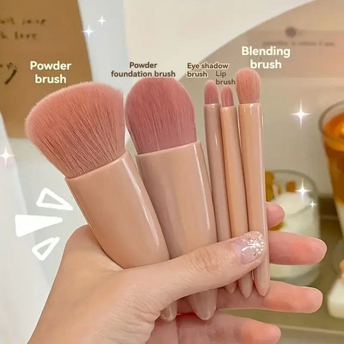 Set of makeup brushes held in a hand with labels on a blurred background