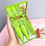 Set of green makeup brushes in a compact case held by a hand against a light background