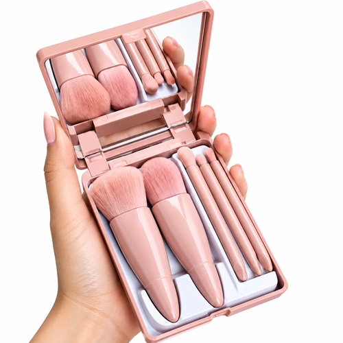 A hand holds an open compact makeup brush set with pink handles, matching pink brushes, a mirror, and applicators on a white background.